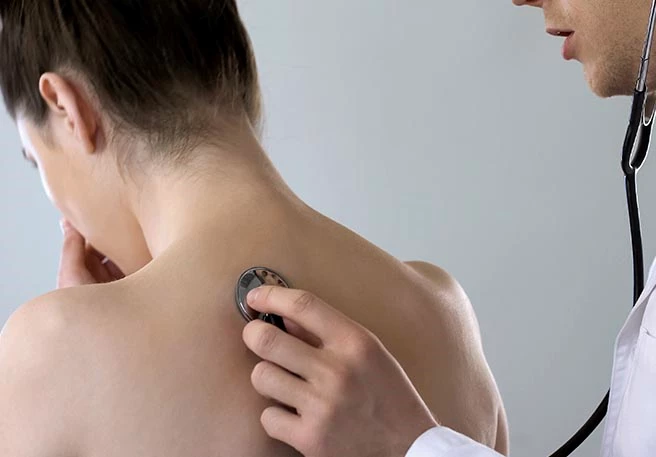 Arzt hört Lunge ab Bei produktivem Husten zum Arzt