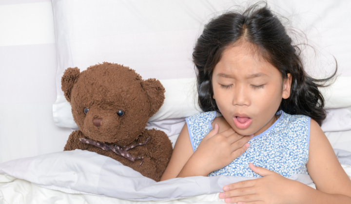 Mädchen mit Husten im Bett Mädchen liegt mit Teddybär im Bett und hustet